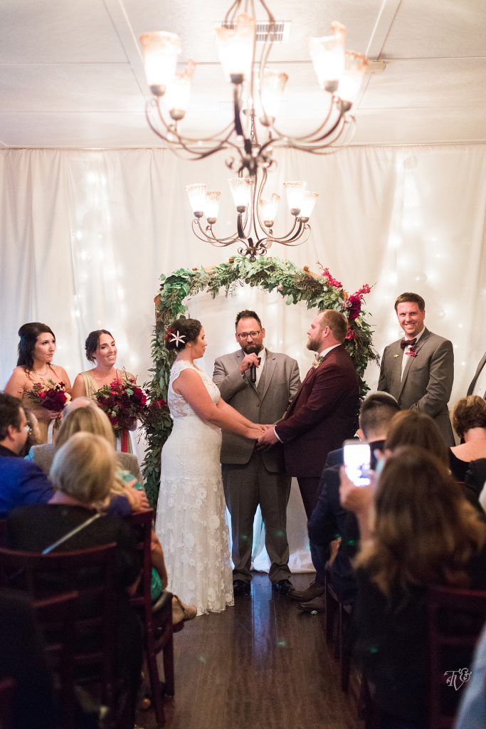 Cozy indoor reception with greenery, candlelight, and dance floor